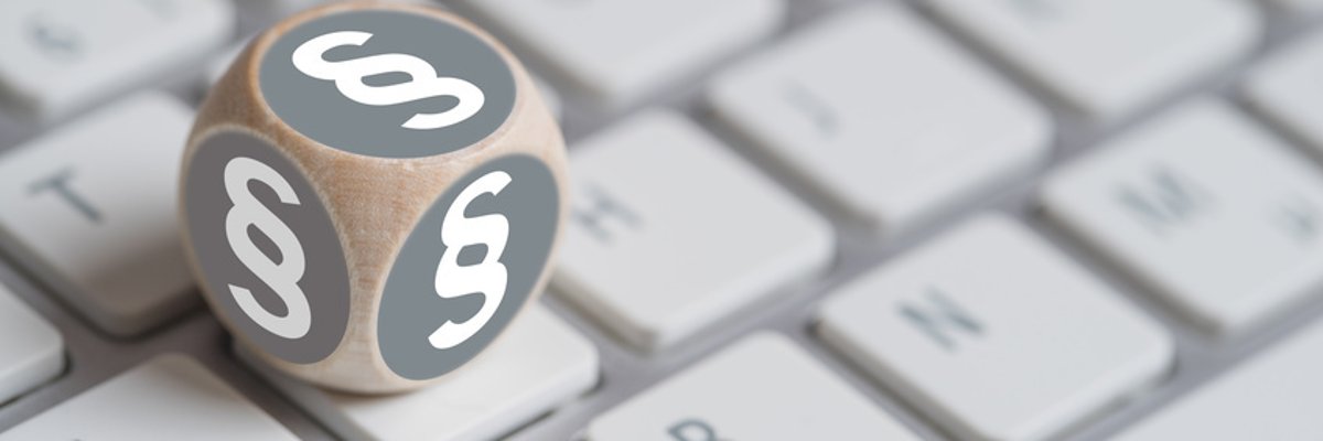 Würfel mit Paragraph Symbolen auf einer Tastatur